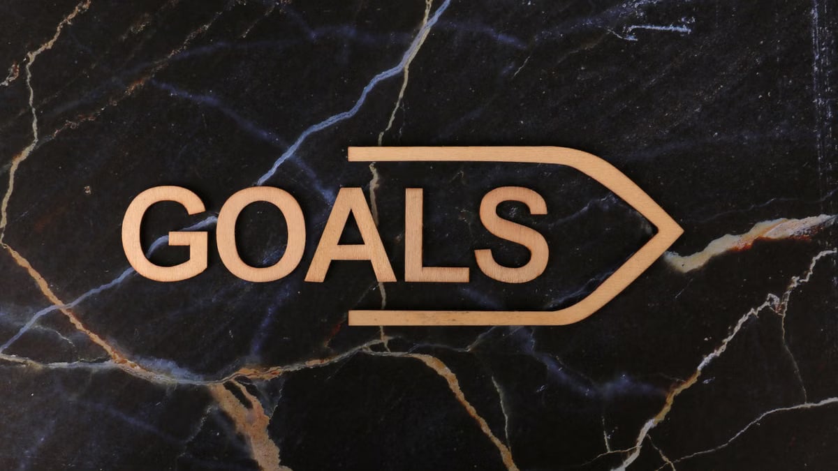 Inspiring image of a wooden 'GOALS' sign on a dark marble surface, symbolizing ambition.